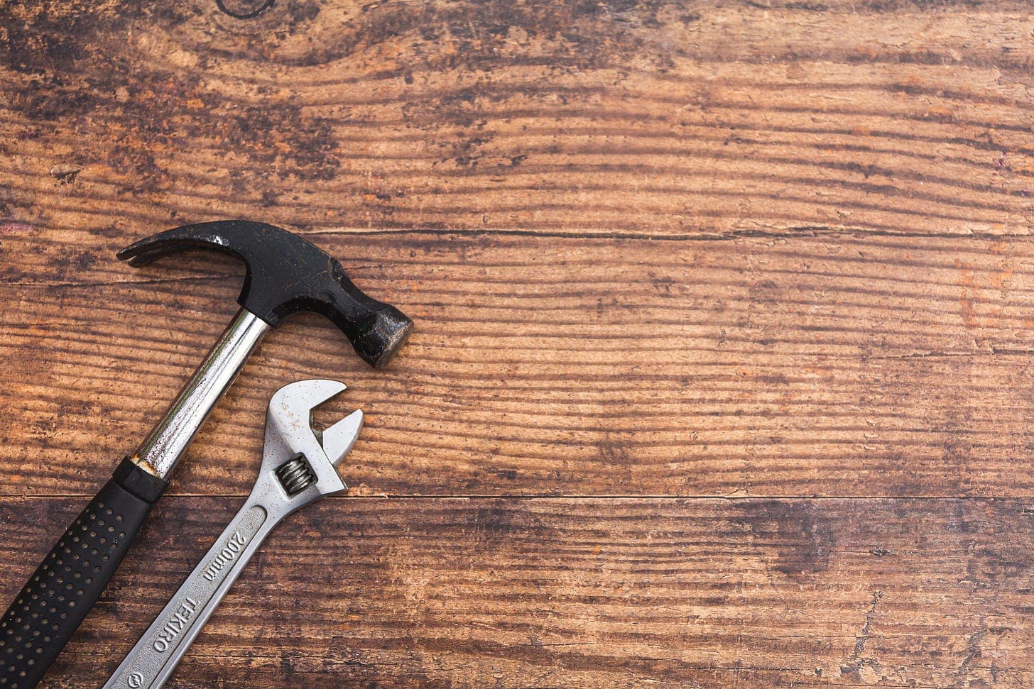hammer and wrench on a wooden table